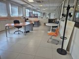 a room with a desk, chairs, and a lamp in it