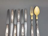 cinq fourchettes, une cuillère et un couteau sur une table