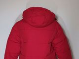 the jacket is red and has a hood that is attached to the back of the jacket