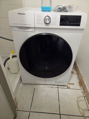 une machine à laver dans un coin de la salle de bains