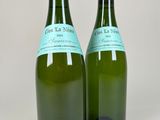 pair of green wine bottles with labels on them sitting on a white surface
