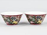 a pair of red and white bowls with flowers on them