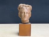 sculpture of a woman ' s head on a wooden block