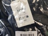 a label on a black shirt that is on a plastic bag