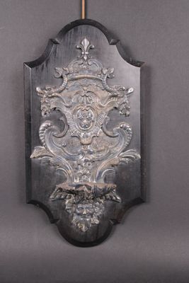une plaque métallique accrochée au mur sur laquelle figure une horloge
