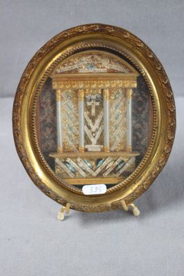 une photo d'une horloge miniature exposée dans un cadre doré