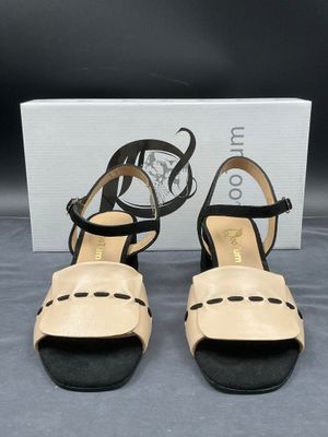 une paire de sandales pour femme, noires et beiges, avec des lanières noires