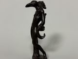 a black statue of a man holding a bird in his hand