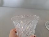 a person holding a clear glass vase on a table