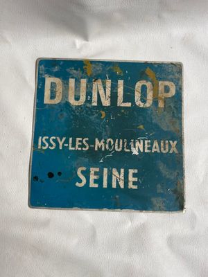 un panneau bleu sur lequel est inscrit « Dunlop »