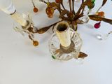a chandelier that has a glass candle holder on it