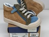 pair of brown and blue sneakers sitting on top of a cardboard box