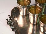 four shot glasses on a silver tray on a table