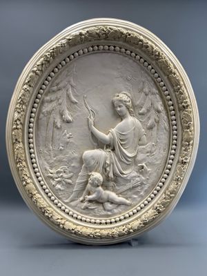 une assiette blanche ornée d'un relief représentant une femme et un homme
