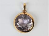 a close up of a gold plated pendant with a faceted amethorate