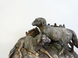 a statue of a dog and a sheep on top of a rock