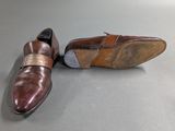 pair of men ' s brown leather shoes on a grey surface