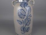a blue and white vase with a handle on a table