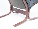 a black leather chair with a wooden frame on a white background
