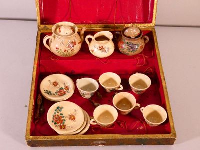 a red box with a set of cups and saucers in it