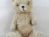 un ours en peluche assis sur une surface blanche