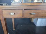a wooden table with two drawers and a mirror on top