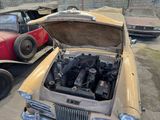 two old cars parked next to each other in a parking lot