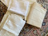 a lot of white linens on a rug on the floor