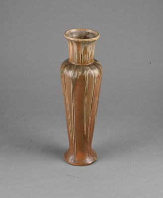a brown vase that is sitting on a gray surface