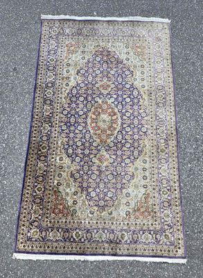an oriental rug is laying on the ground in a parking lot