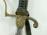 a close up of a sword on a white surface