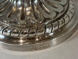 a silver candle holder with a flower on it