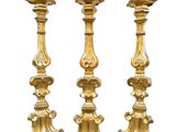 two gold candlesticks with apples on a white background