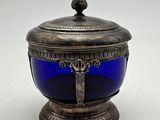 an antique silver and blue glass bowl with a bird on top