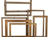 a set of five gold picture frames on a white background