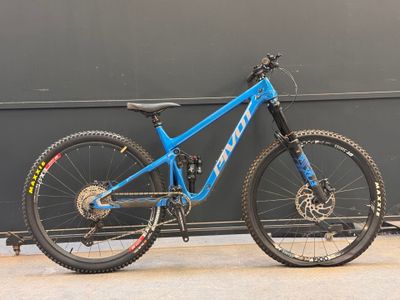 un VTT bleu appuyé contre un mur