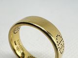 gros plan d'une bague en or sur une surface blanche
