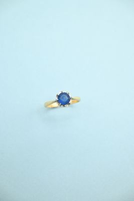 a close up of a blue sapphire ring on a white surface