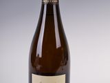 an old bottle of wine sitting on top of a white table