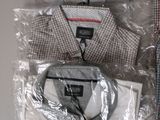 three men ' s dress shirts wrapped in plastic on a table