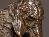bronze statue of a dog on a pedestal with a black background