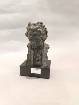 statue d'un homme coiffé d'un chapeau, assis sur un socle en bois