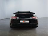 the back of a black porsche gts parked in a white room