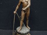 bronze statue of a man with a stick and a cane