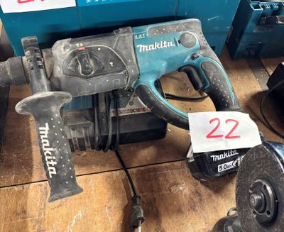 une photo représentant un marteau et une perceuse posés sur une table