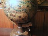 a glass of wine sitting on a table next to a globe