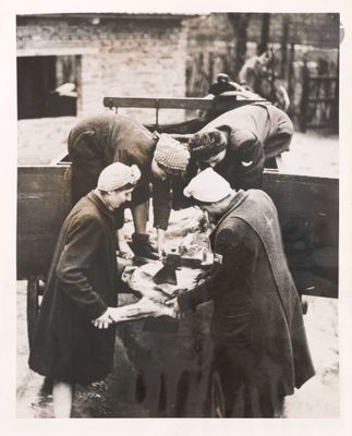 many men standing around a table with food on it