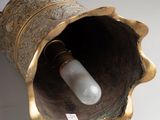 a gold vase with a light bulb inside of it