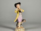 une figurine représentant un garçon et un chien posée sur une table
