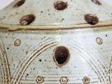a close up of a white vase with holes in it